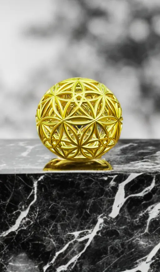 Flowers of Life Sphyr: a gold sphere patterned with overlapping six-petal circles, on black marble