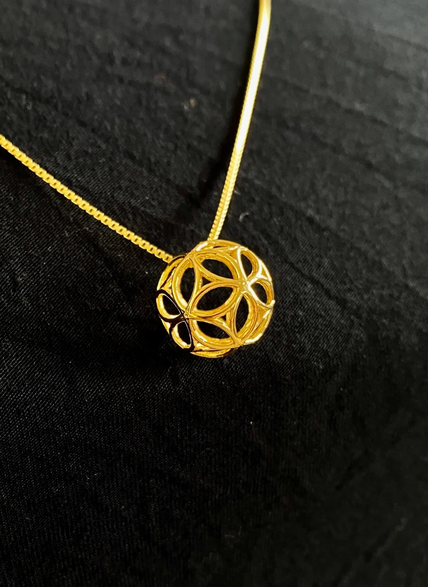 PentaSphyr gold pendant on a chain, angled view