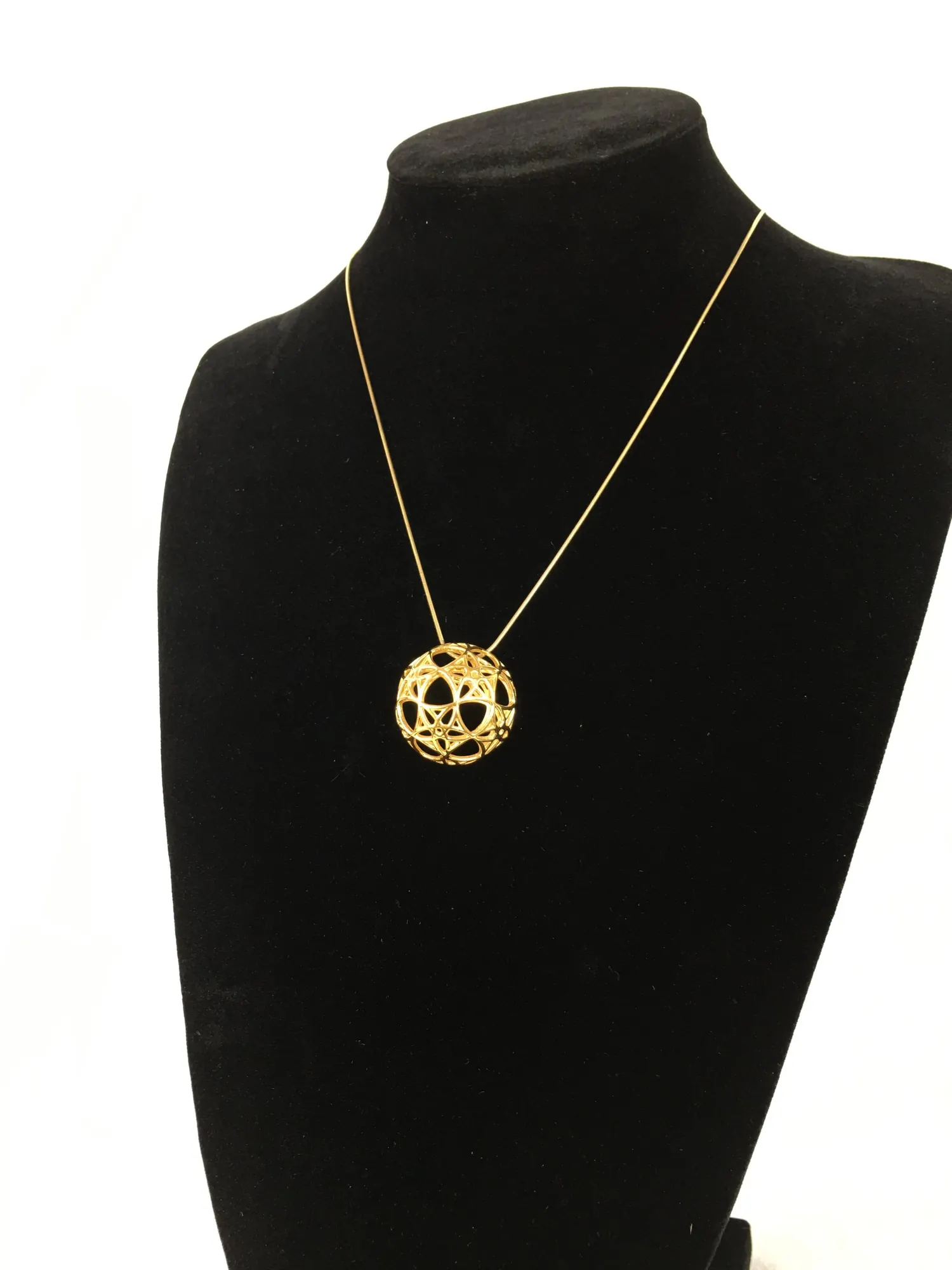 14k gold plated AllSphyr pendant on a black necklace bust, angled view