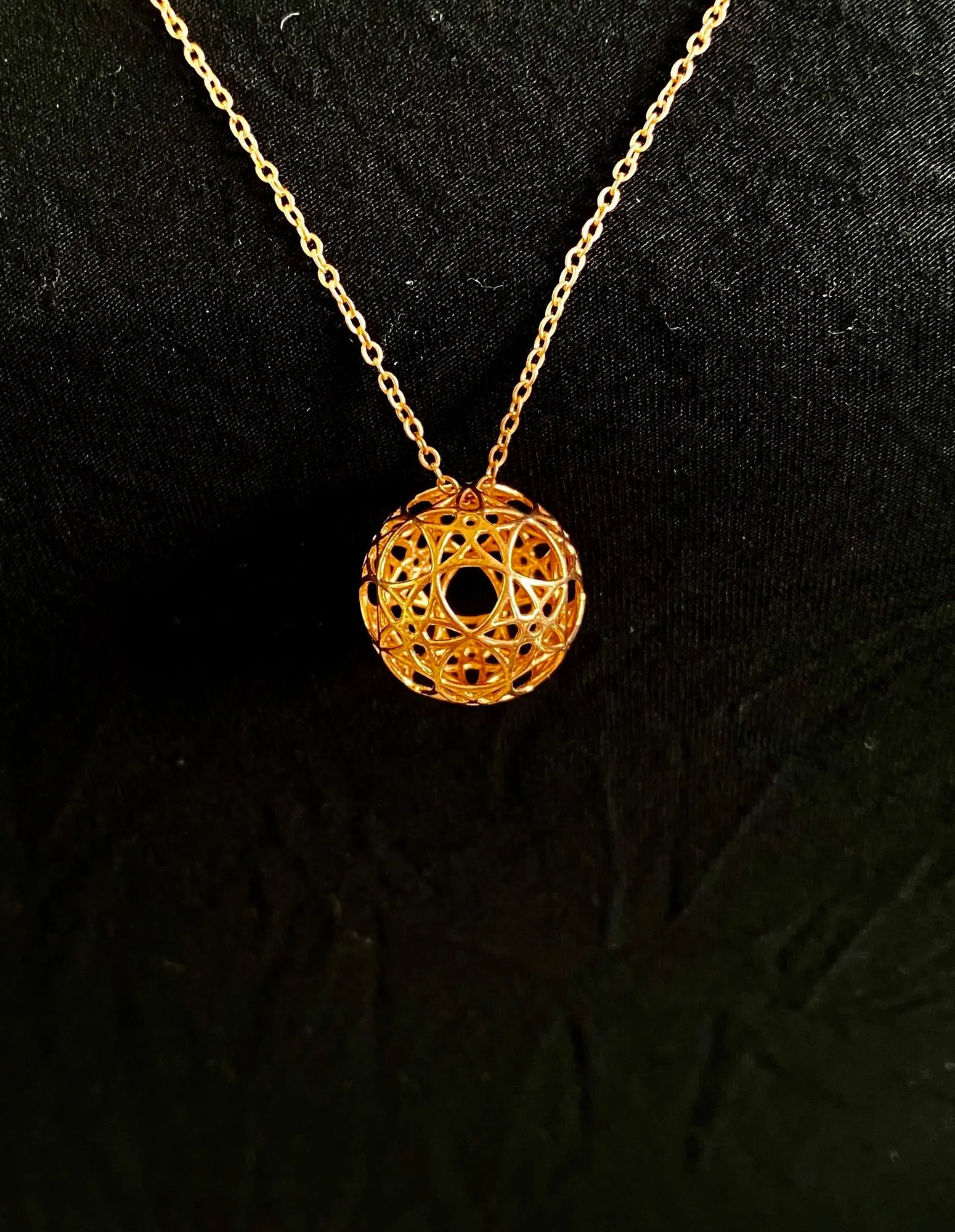 Copper AllSphyr pendant on a copper chain, angled view