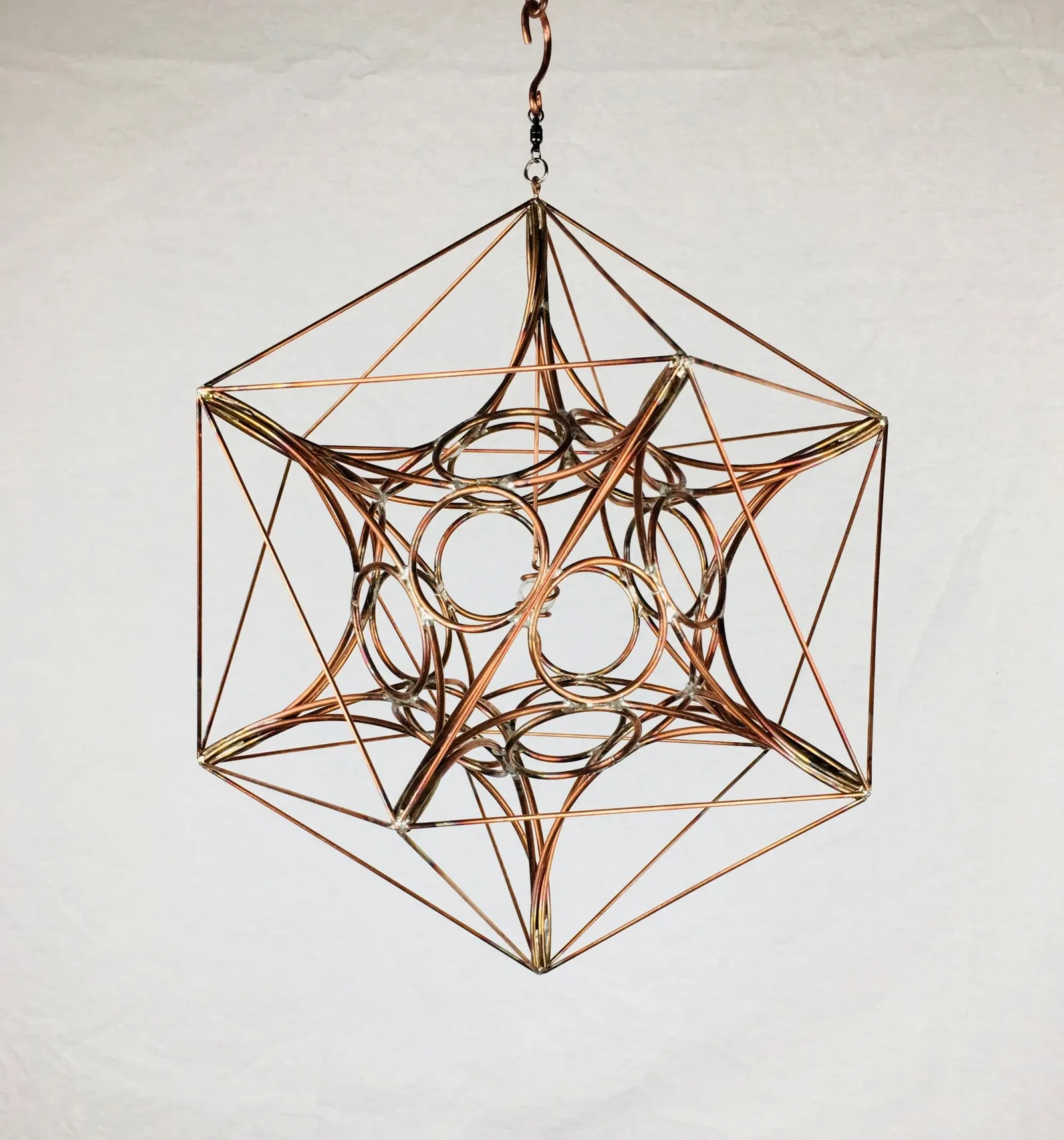 IcosaSphyr copper sculpture viewed at an angle showing overlapping pentagonal openings