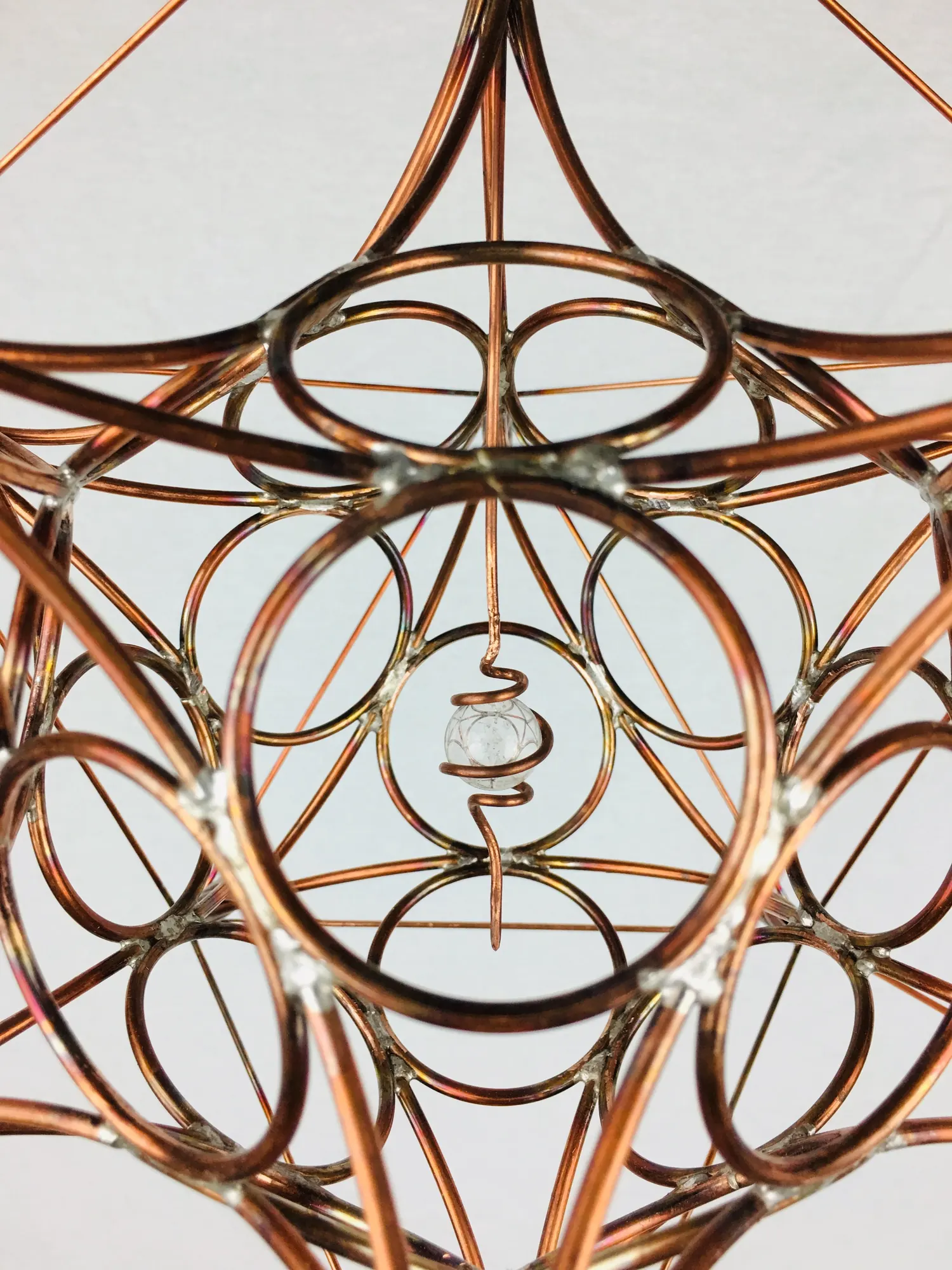 Close detail of the copper rings and a small crystal at the center of IcosaSphyr