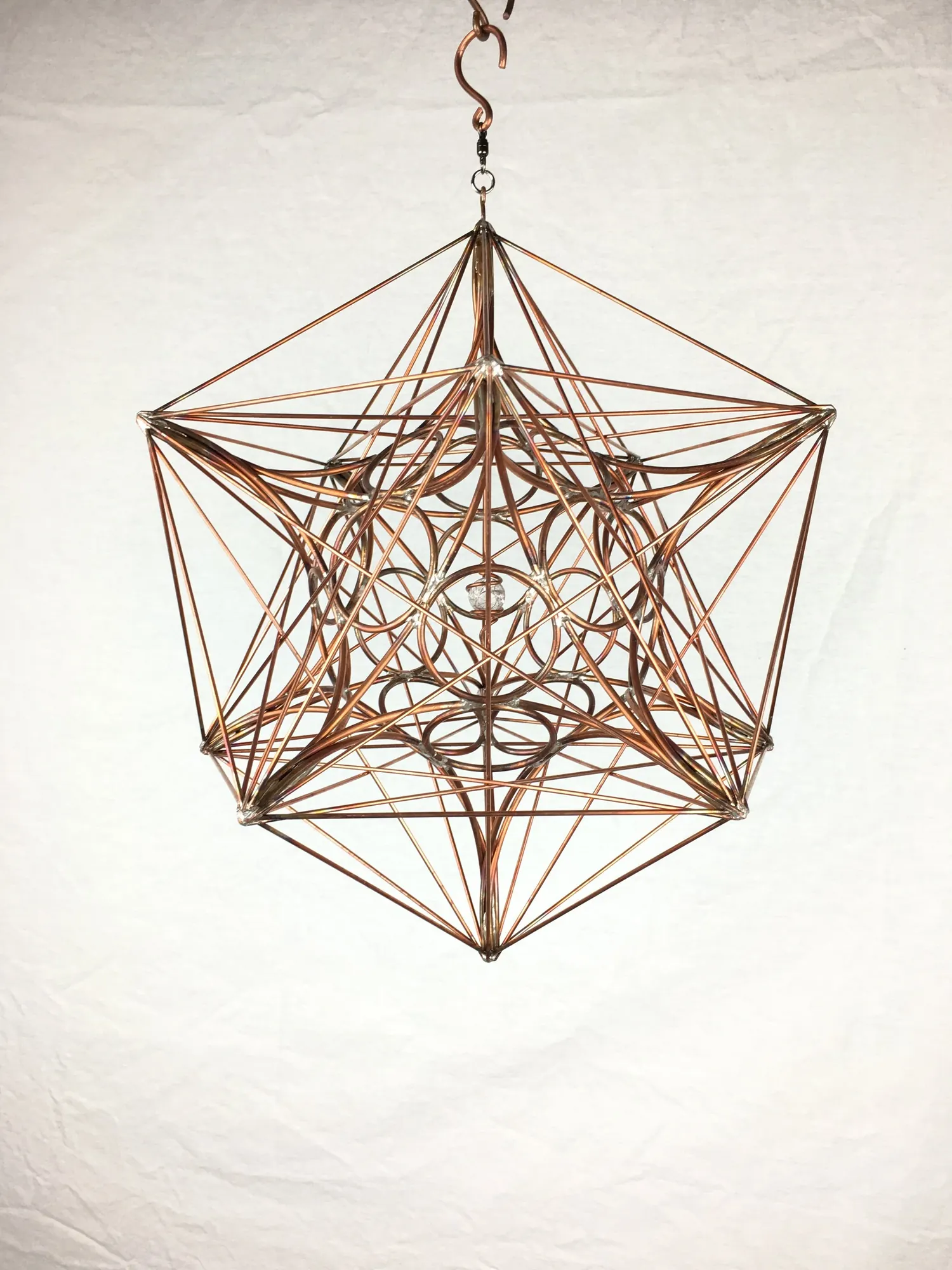 Metatron's Cube copper wire sculpture hanging from a hook, viewed straight on