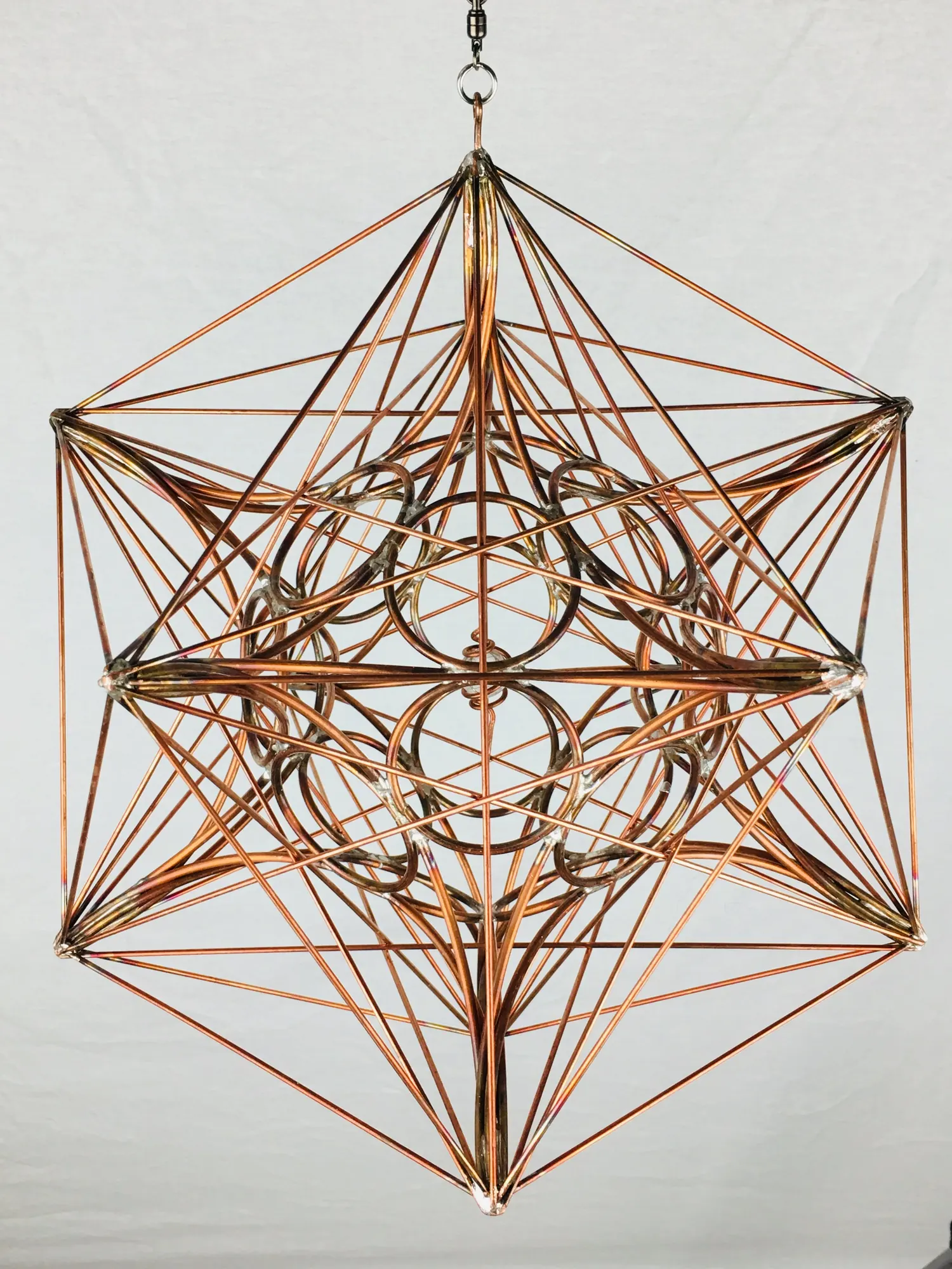 Metatron's Cube copper sculpture filling the frame, with its twelve-point outer structure visible