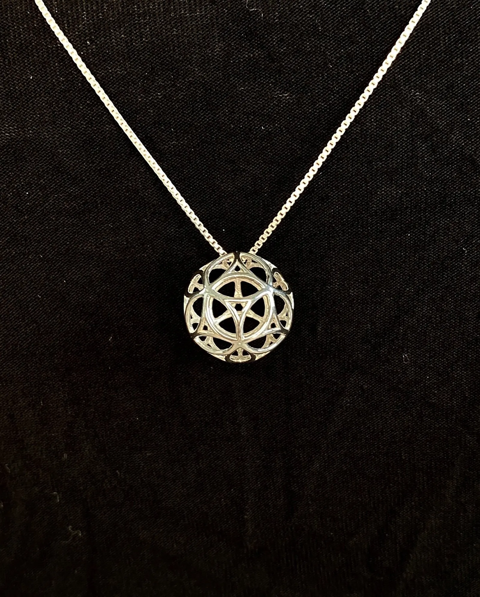 Silver PentaSphyr pendant on a silver chain, angled view