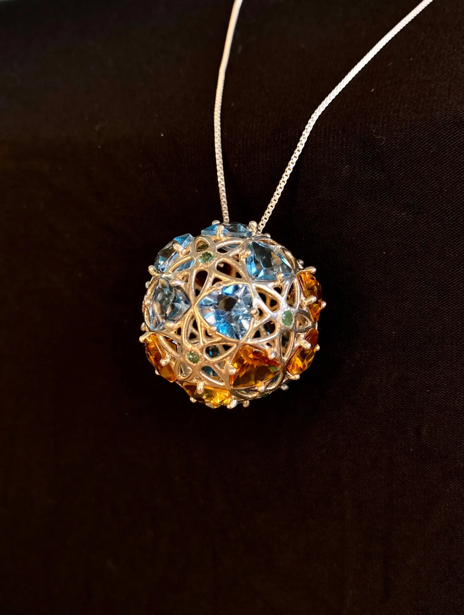 GemSphyr pendant on a silver chain showing its gem-set pentagonal faces