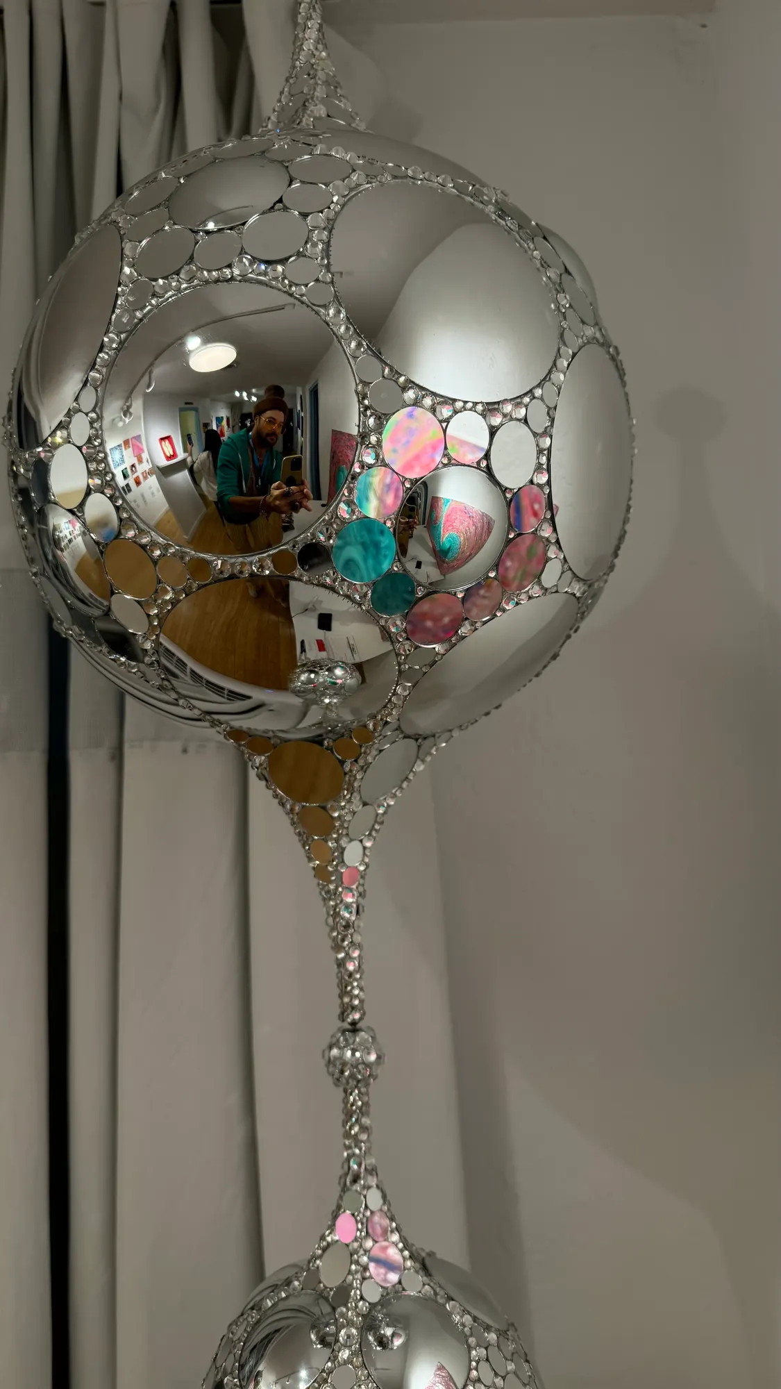 Close view of the Teardrop DiscoSphyr's convex mirrors and rhinestone lattice reflecting a room