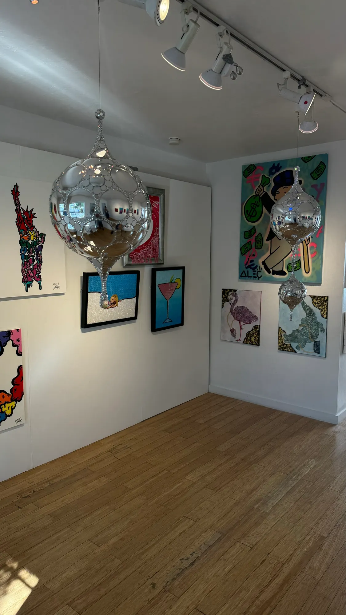 Galactic DiscoSphyr suspended in a gallery with wooden floors and track lighting